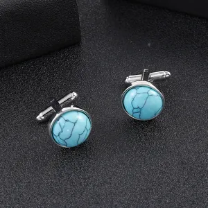 Macro detail of round cufflinks with turquoise stone and polished silver metal base