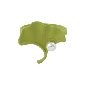 Servilletero vintage de hoja de ginkgo verde con perla blanca en fondo blanco