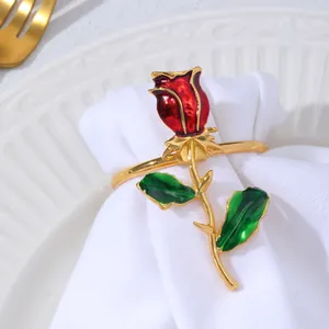 Dettaglio dell'anello portatovagliolo a forma di rosa con smalto rosso su tovagliolo bianco