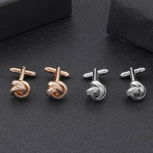 Macro view of woven twist knot shirt cufflinks in rose gold and polished silver metal