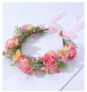 Détail de couronne de fleurs pour mariée avec roses roses et rubans de soie