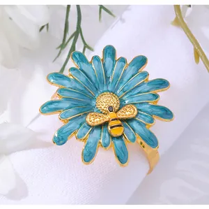 Detailed macro shot of daisy napkin ring with blue enamel petals and a golden bee