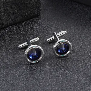 Close-up of round deep blue gemstone cufflinks with polished silver metal frame