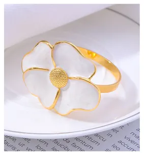 Detailed close-up of a daisy napkin ring with white petals and golden center on a plate