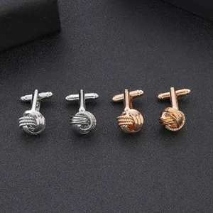 Dettaglio macro di gemelli a nodo intrecciato in argento e oro per camicie eleganti