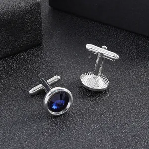Detail of silver-plated cufflinks with navy blue crystal and toggle closure mechanism