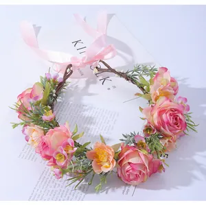 Détail d'une couronne de fleurs de mariée avec roses roses, marguerites et ruban de soie