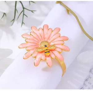 Detailed view of pink daisy napkin ring with a golden bee on white napkin