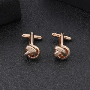 Close-up of rose gold twist knot cufflinks for men on a premium black textured surface