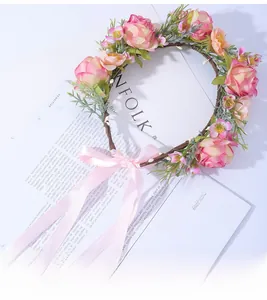 Détail d'une couronne de roses roses avec feuilles vertes et ruban de satin ajustable