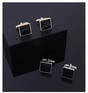Detail of square alloy cufflinks in gold and silver finish with black enamel insets