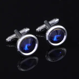 Detailed close-up of round blue crystal cufflinks with a polished silver metal base