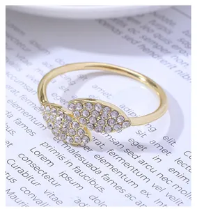 Detailed close-up of golden clover leaf napkin ring with sparkling inlaid rhinestones
