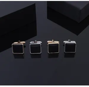 Close-up of square geometric cufflinks with black enamel in gold and silver finish