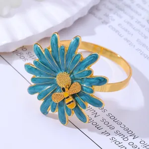 Golden alloy daisy napkin ring with enamel teal petals and tiny honey bee detail
