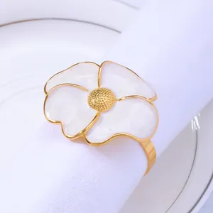 Elegant gold daisy flower napkin ring with white petals on a luxury white cloth