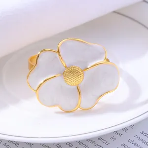 Daisy flower napkin ring with white petals and gold core on a white ceramic plate
