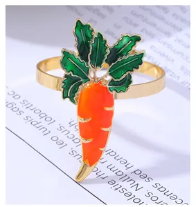 Detail of carrot napkin ring with orange enamel finish and polished gold band