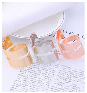 Detalle de servilleteros en espiral pulidos en oro, plata y oro rosa sobre la mesa