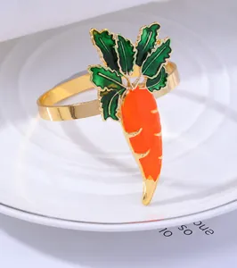Macro detail of golden carrot napkin ring with vibrant orange and green enamel finish