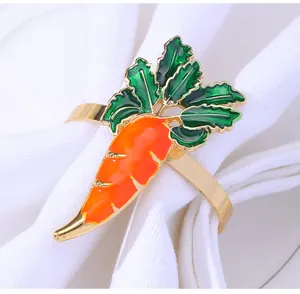 Detailed view of carrot napkin ring with orange enamel and gold finish on white cloth
