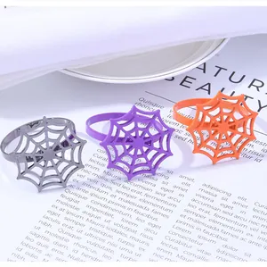 Close-up of spider web napkin rings in orange, purple, and gunmetal for Halloween decor