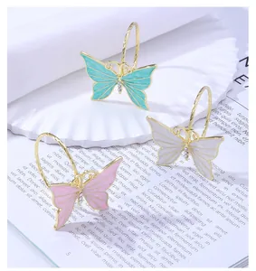 Detalle de ganchos de cortina de ducha mariposa en azul, rosa y blanco con esmalte y cristales