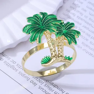 Tropical coconut tree gold metal napkin ring with green enamel finish on a white plate