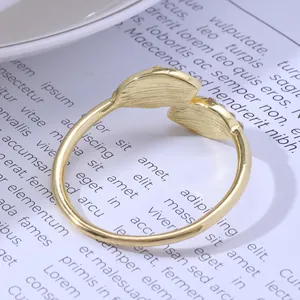 Adjustable golden double-leaf napkin ring with brushed texture on vintage background