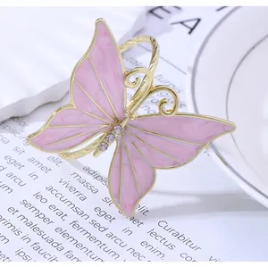 Detalle de servilletero de mariposa dorada con esmalte jaspeado rosa y pedrería