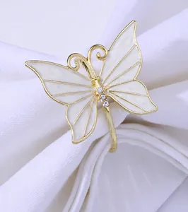 Close-up of golden butterfly napkin ring with white marble enamel and sparkling crystals