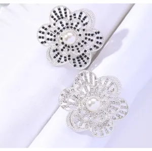 Detail of silver flower napkin ring with pearls and crystals on white fabric