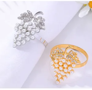 Detalle del servilletero de uva con perlas blancas y diamantes sobre tela blanca