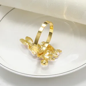 Detalle de un servilletero de conejo dorado con perlas blancas en plato blanco