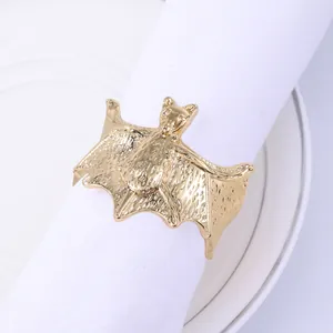 Detailed close-up of golden metal bat napkin ring with intricate wing textures