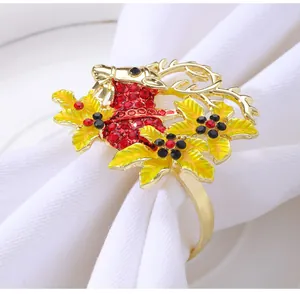 Detailed close-up of golden reindeer napkin ring with red rhinestones on white napkin