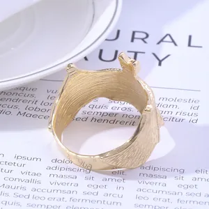 Macro shot of golden crown napkin ring with brushed metal texture on a white bowl