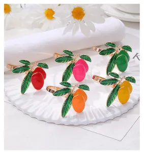 Macro detail of mango-shaped alloy napkin rings with colorful enamel finishes