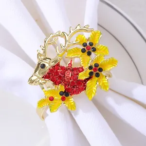 Golden Christmas reindeer napkin ring with red rhinestones on a white linen napkin