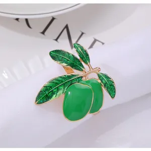 Macro shot of olive fruit napkin ring with gold finish and green enamel details