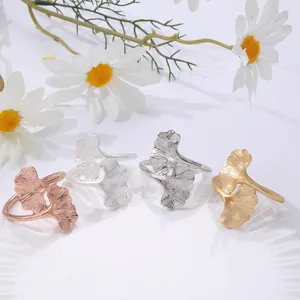Ginkgo leaf napkin rings set in four metallic finishes on a decorative white porcelain plate