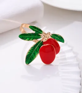 Macro detail of red fruit napkin ring with glitter green leaves and golden alloy loop