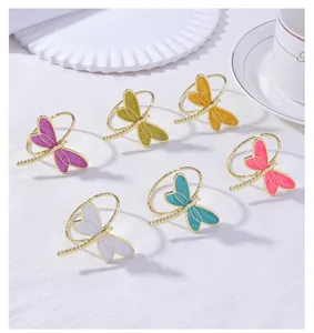 Macro detail of colorful enamel dragonfly napkin rings with gold twisted metal bands
