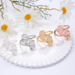 Vintage ginkgo leaf napkin rings set in gold and silver finish on ceramic tray
