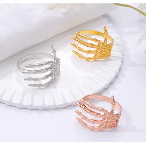 Detalle de los servilleteros de mano de esqueleto en acabados oro, plata y oro rosa