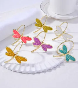 Detailed view of colorful enamel dragonfly napkin rings on a white decorative plate