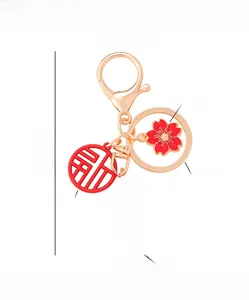 Detail of Chinese keychain with red cherry blossom, Fu charm and inspiring inscription