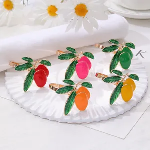Set of 5 colorful mango-shaped alloy napkin rings on a white plate with gold finish