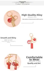 Detailed view of golden alloy keychains with red enamel auspicious text and sakura charms