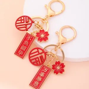 Golden Chinese style keychain with red enamel charms and lucky characters for success